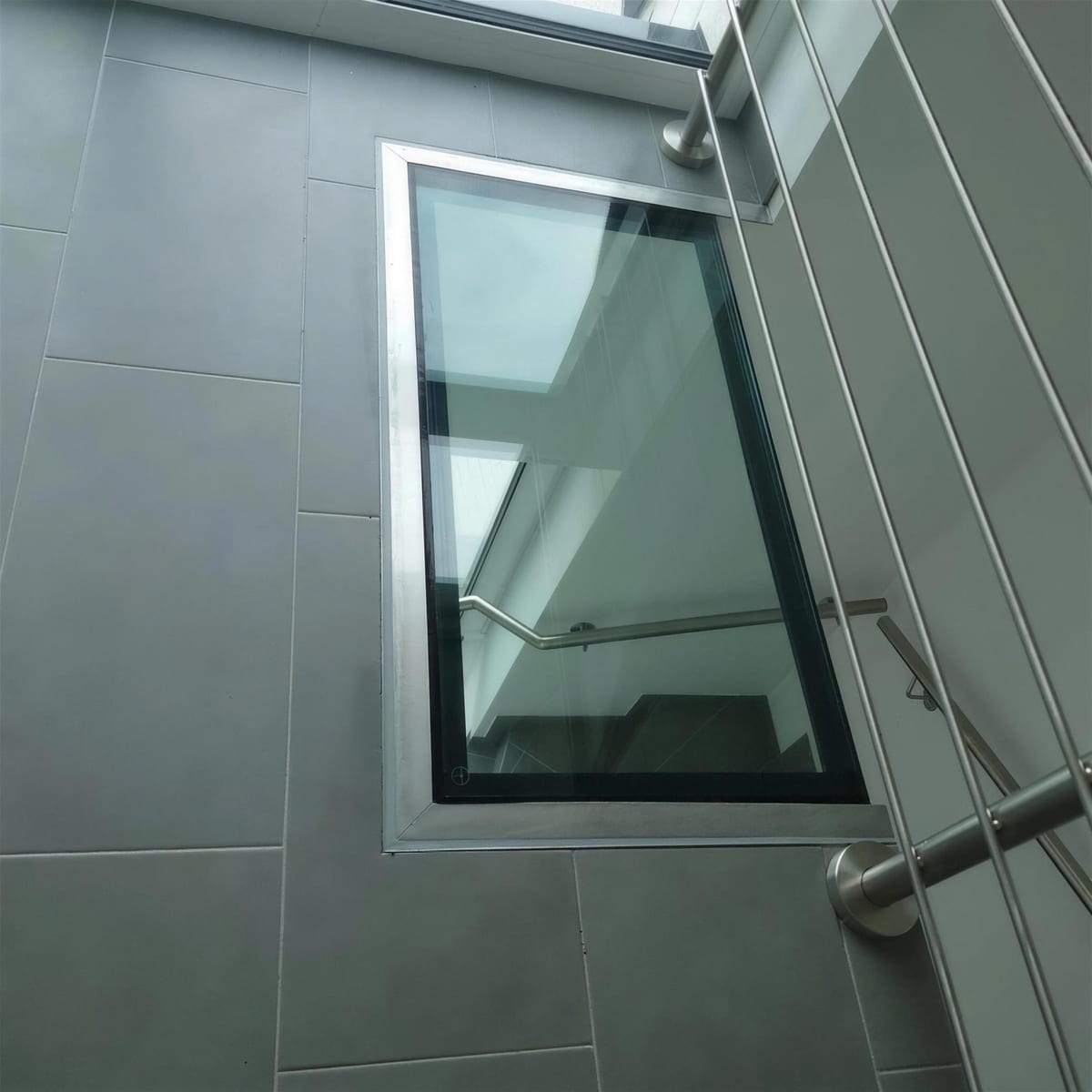 Begehbares Glaselement im Fußboden mit Blick auf die Treppe darunter