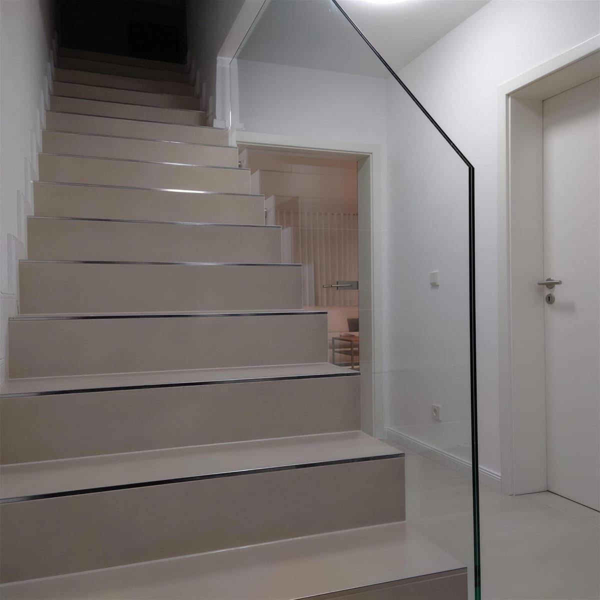 Frei stehende Glasscheibe als Treppengeländer, ohne Handlauf, in hellem Treppenhaus